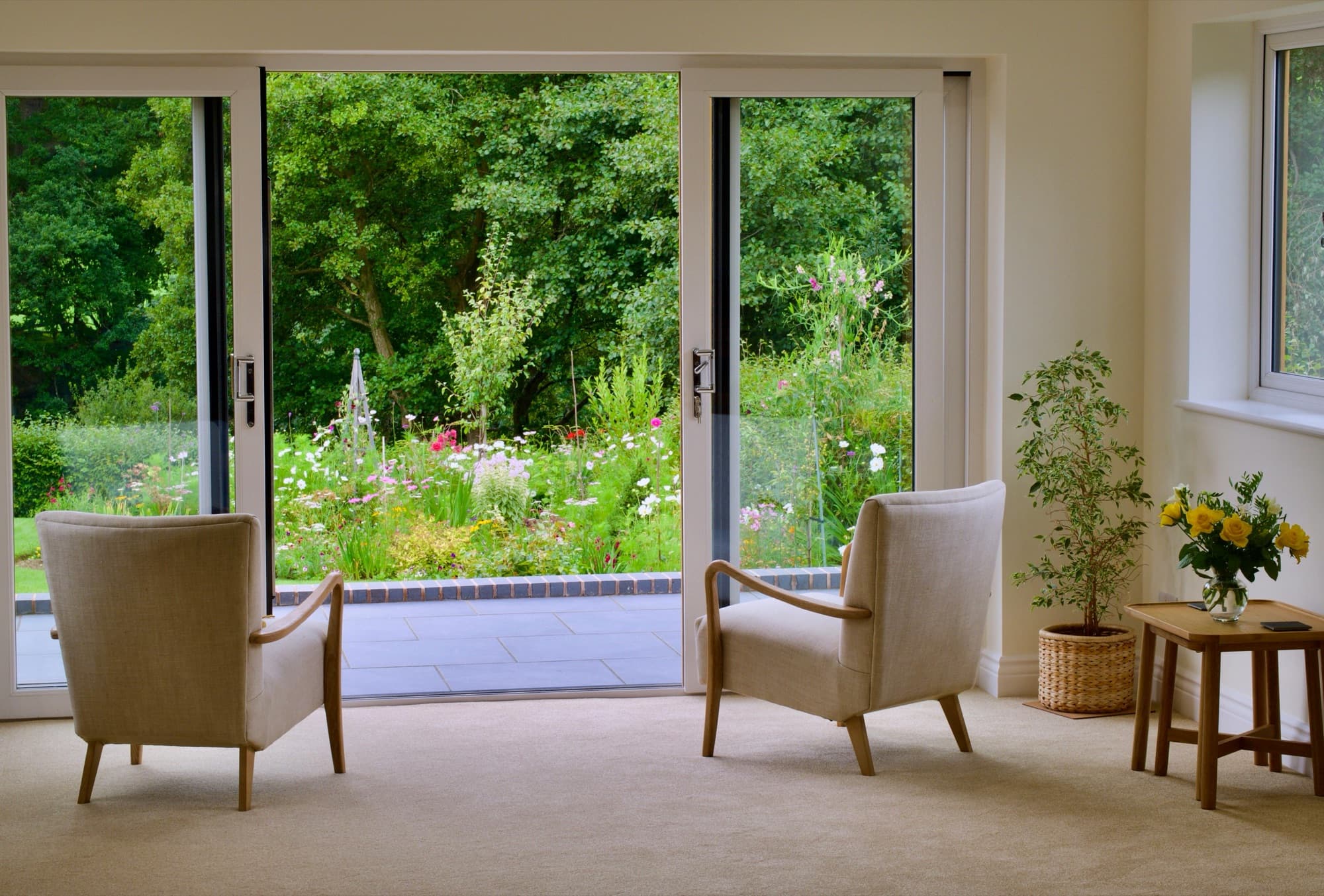 Interior living room with open patio door looking out onto a green garden